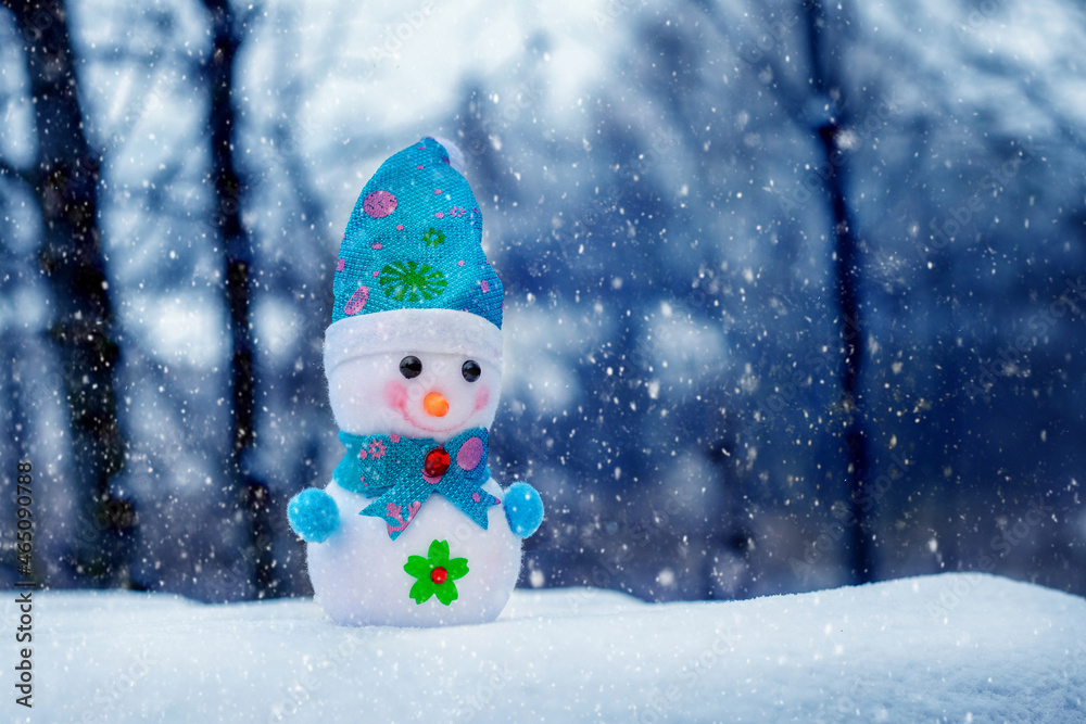 Obraz premium Snowman in the forest during a snowfall. Christmas and New Year greeting card