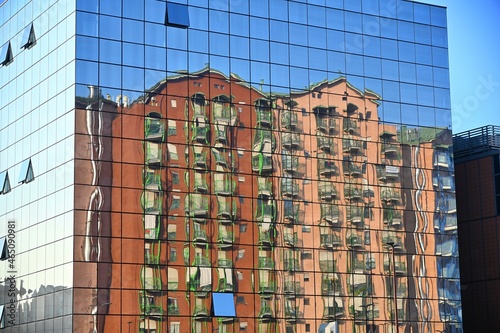 distorted reflection of residential buildings in the mirror facade