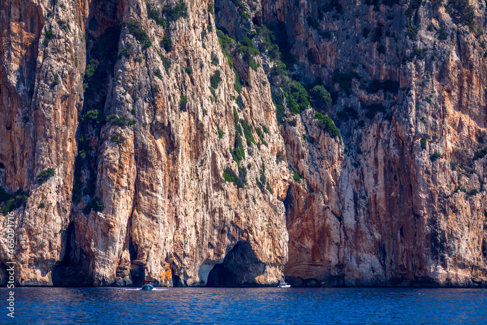 Blue sea and the characteristic caves of Cala Luna, a beach in the Golfo di Orosei, Sardinia, Italy. Big sea caves in the mediterranean coast. Sardinia, Italy.