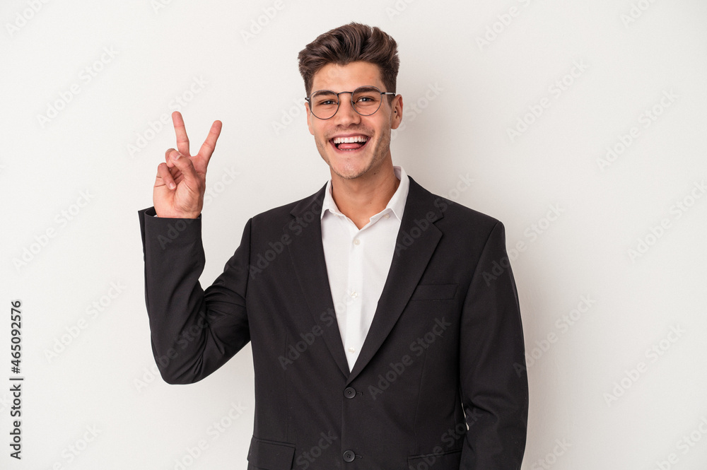 Young business caucasian man isolated on white background joyful and carefree showing a peace symbol with fingers. Young business caucasian man isolated on white background joyful and carefree showing a peace symbol with fingers.