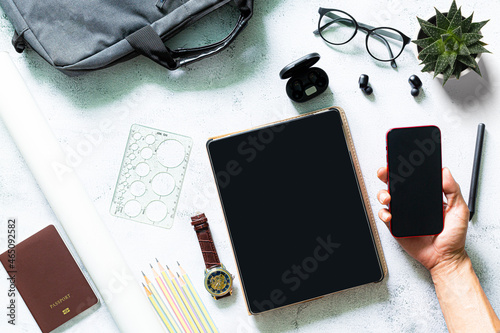 Home office workspace mockup with laptop, clipboard, notebook and accessories.Man writes on clipboard. Male hands holding a pen and coffee. Flat lay, top view