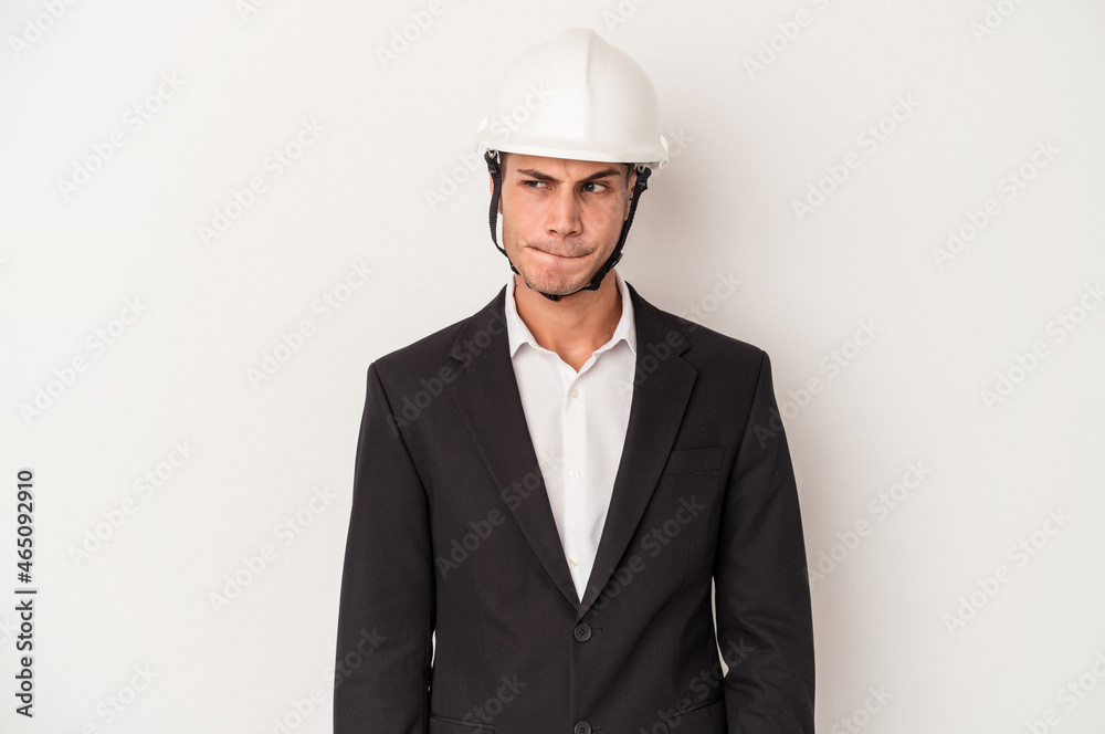Young architect caucasian man isolated on white background confused, feels doubtful and unsure. Young architect caucasian man isolated on white background confused, feels doubtful and unsure.