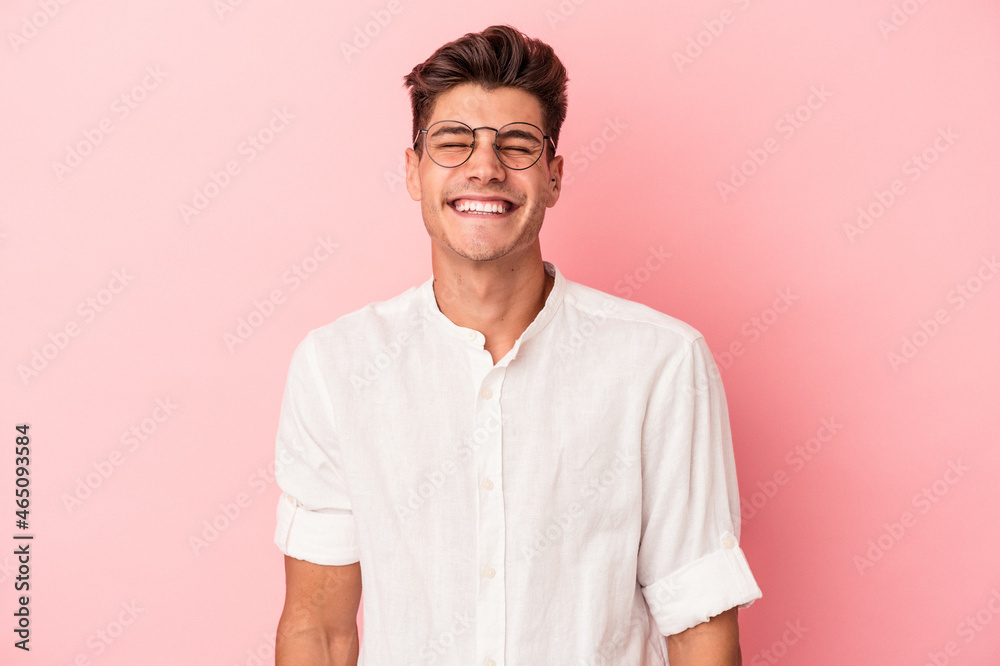 Young caucasian man isolated on pink background laughs and closes eyes, feels relaxed and happy. Young caucasian man isolated on pink background laughs and closes eyes, feels relaxed and happy.