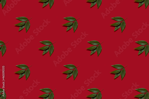 A pattern of green leaves on red background