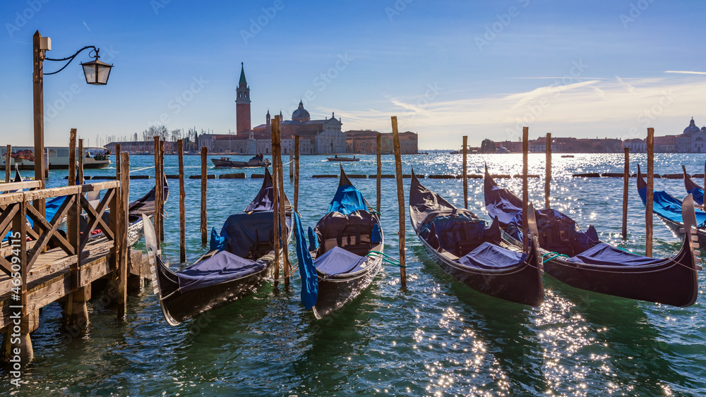 Gondolas moored near San Marco square across from San Giorgio Maggiore island in Venice, Italy. Gondolas were once the main form of transportation around the Venetian canals. Venice, Italy.