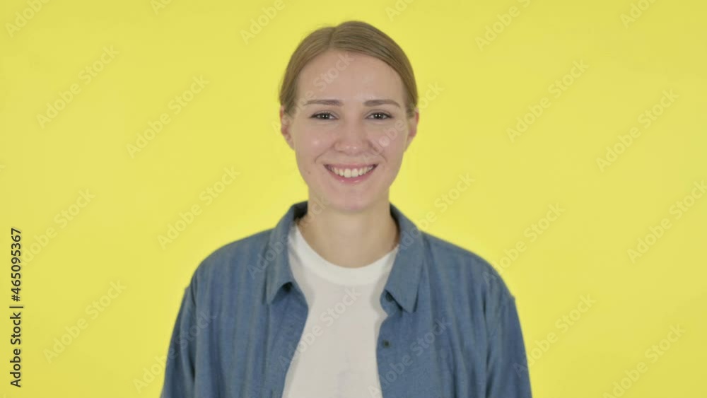 Young Woman Smiling at Camera on Yellow Background Young Woman Smiling at Camera on Yellow Background