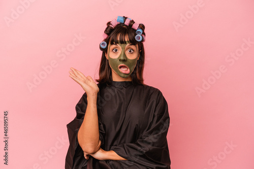 Young mixed race woman waiting in a Beaty salon isolated on pink background surprised and shocked. © Asier