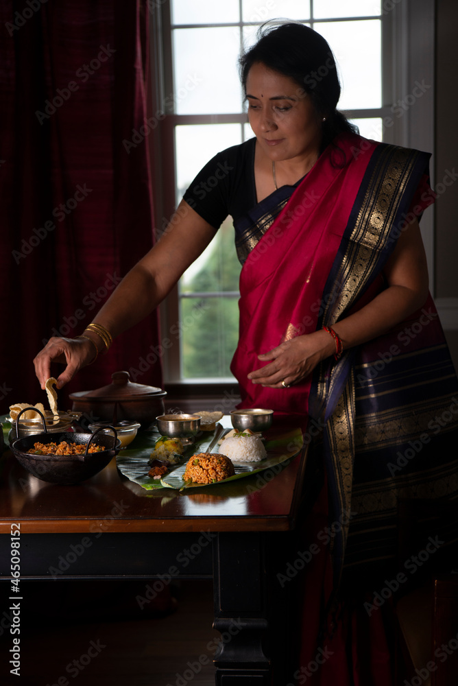 Woman in sari setting table for Diwali dinner Woman in sari setting table for Diwali dinner