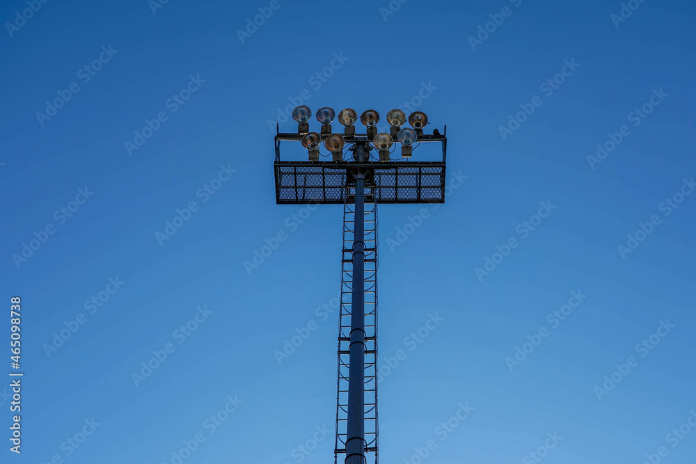 Naklejka premium Photo of a lighting mast on a football field against a blue clear sky