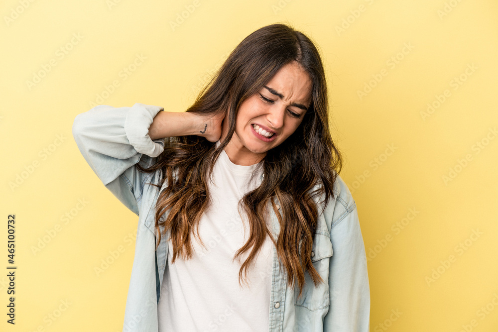Young caucasian woman isolated on yellow background suffering neck pain due to sedentary lifestyle. Young caucasian woman isolated on yellow background suffering neck pain due to sedentary lifestyle.