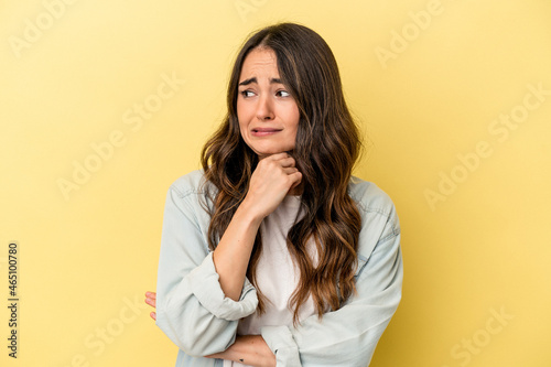 Young caucasian woman isolated on yellow background suffers pain in throat due a virus or infection. © Asier