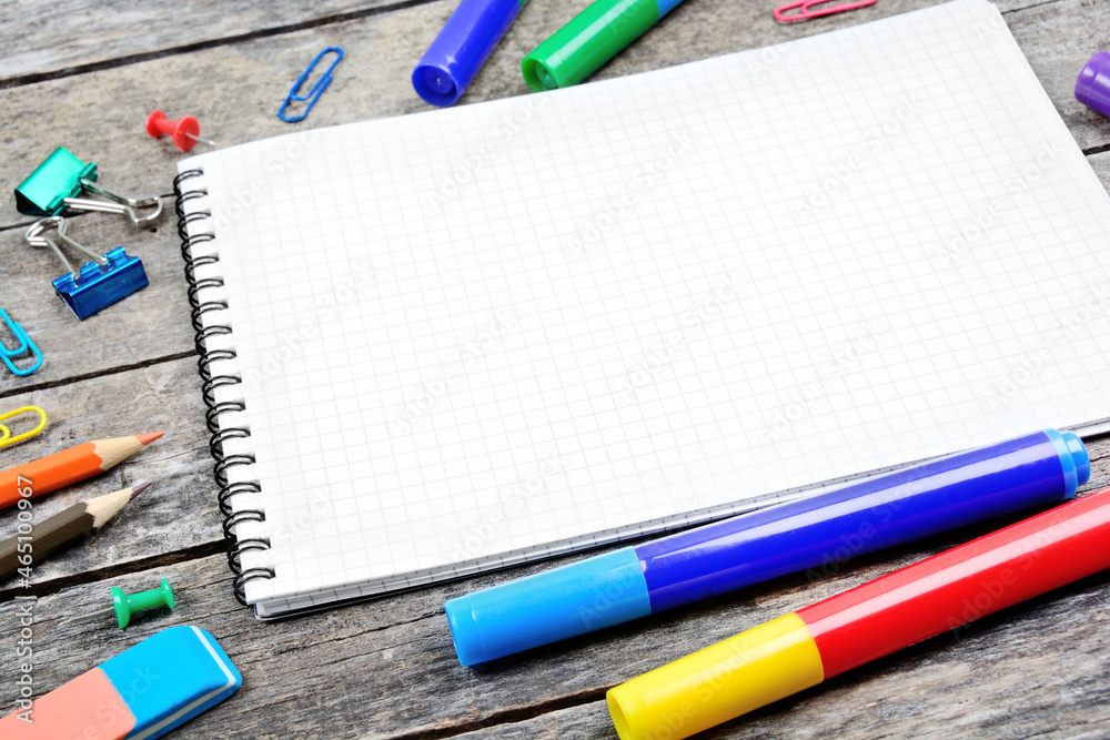 School supplies with empty notebook on wooden desk School supplies with empty notebook on wooden desk