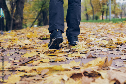 Man walks in autumn park. Top View of hiking Boot. Close-up Legs In J sport trekking shoes in the forest