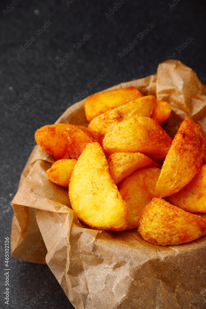 wedges potato in bowl closeup. wedges potato on dark concrete table wedges potato in bowl closeup. wedges potato on dark concrete table