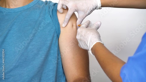 Nurse or medical staff in white gloves putting the vaccine with a needle in the arm to a boy for Covid-19 or coronavirus Sars Cov to avoid becoming seriously ill and the rise of the pandemic.