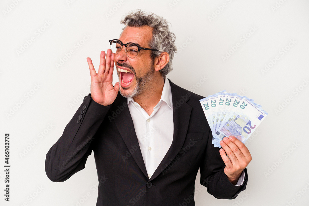 Middle age business man holding bills isolated on blue background shouting and holding palm near opened mouth. Middle age business man holding bills isolated on blue background shouting and holding palm near opened mouth.