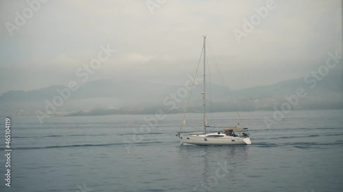 Sailboat sails through the sea at sunset