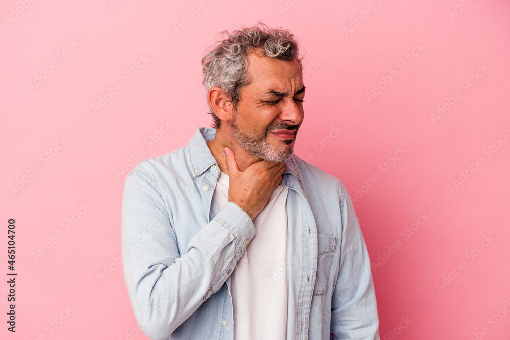 Middle age caucasian man isolated on pink background  suffers pain in throat due a virus or infection.