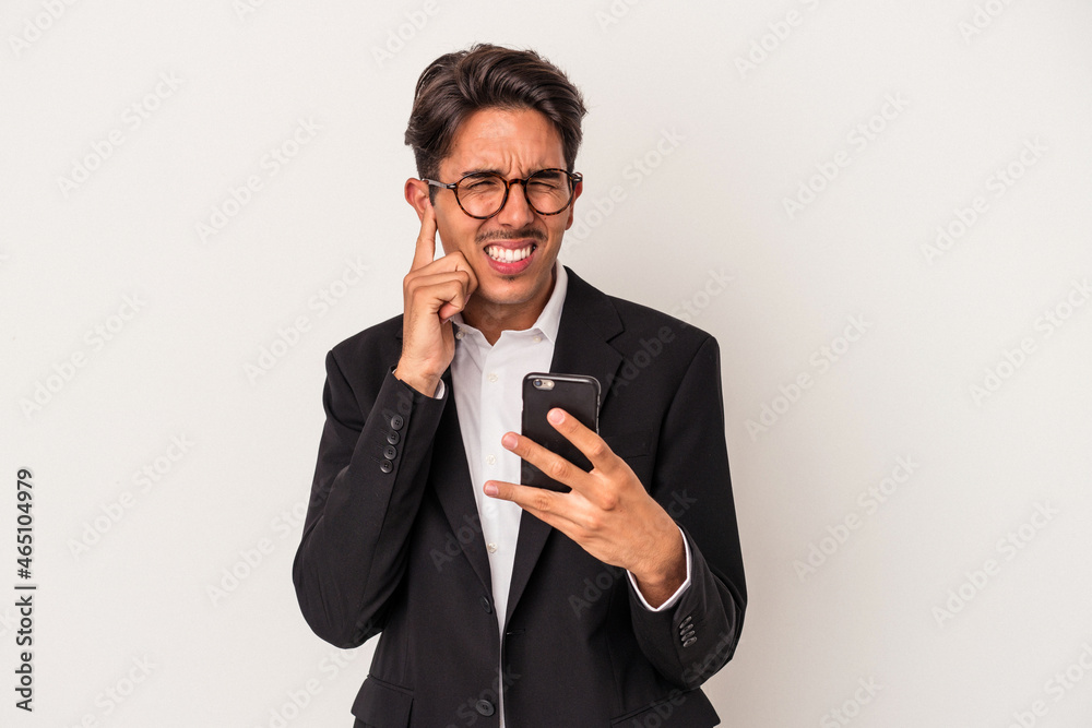Young mixed race business man holding mobile phone isolated on white background covering ears with hands. Young mixed race business man holding mobile phone isolated on white background covering ears with hands.