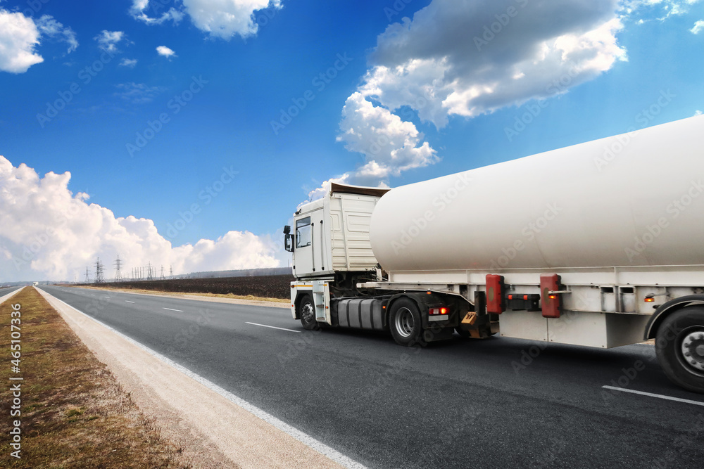 Tanker truck on a countryside road against a sky with clouds Tanker truck on a countryside road against a sky with clouds