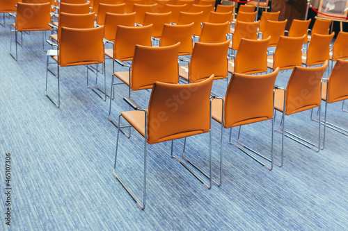 large empty conference room with orange chairs before the auction
