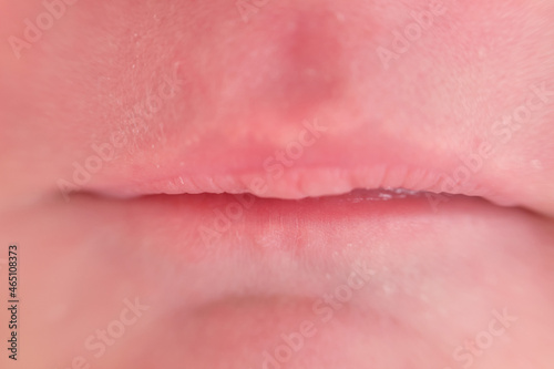 Lips on the face of a newborn baby, close-up. Macro photo of a healthy child mouth