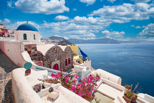 Fototapeta Naklejka Na Ścianę i Meble -  Greek island of Santorini. Amazing travel panorama, white houses, stairs and flowers on the streets. Idyllic summer vacation, urban landscape, tourism destination scenic. Oia, Thira panoramic views