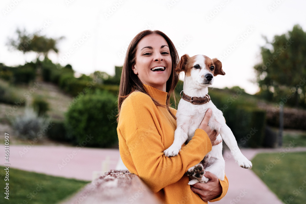 happy caucasian woman having fun with jack russell dog in park,woman holding pet during autumn season. Pets and love concept happy caucasian woman having fun with jack russell dog in park,woman holding pet during autumn season. Pets and love concept