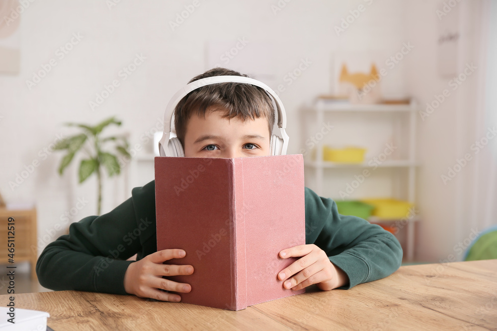 Little boy with book and headphones at home Little boy with book and headphones at home