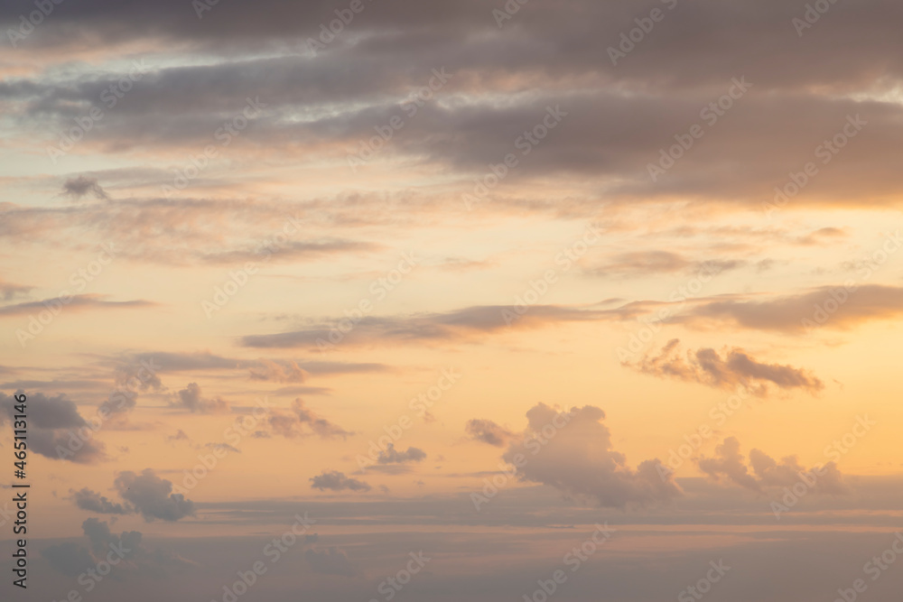 Abstract sunset sky background. Cirrus and cumulus clouds on orange pastel colored sky. Copy space for your text. Beauty in nature theme.