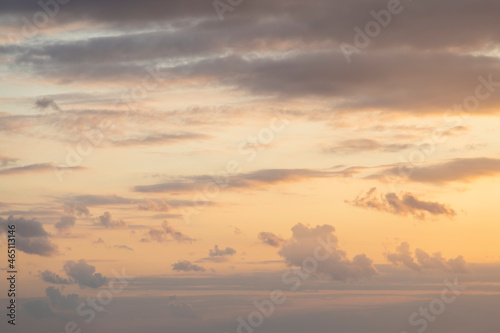 Abstract sunset sky background. Cirrus and cumulus clouds on orange pastel colored sky. Copy space for your text. Beauty in nature theme.