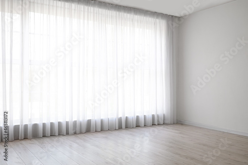 Light curtains on big window in empty room photo