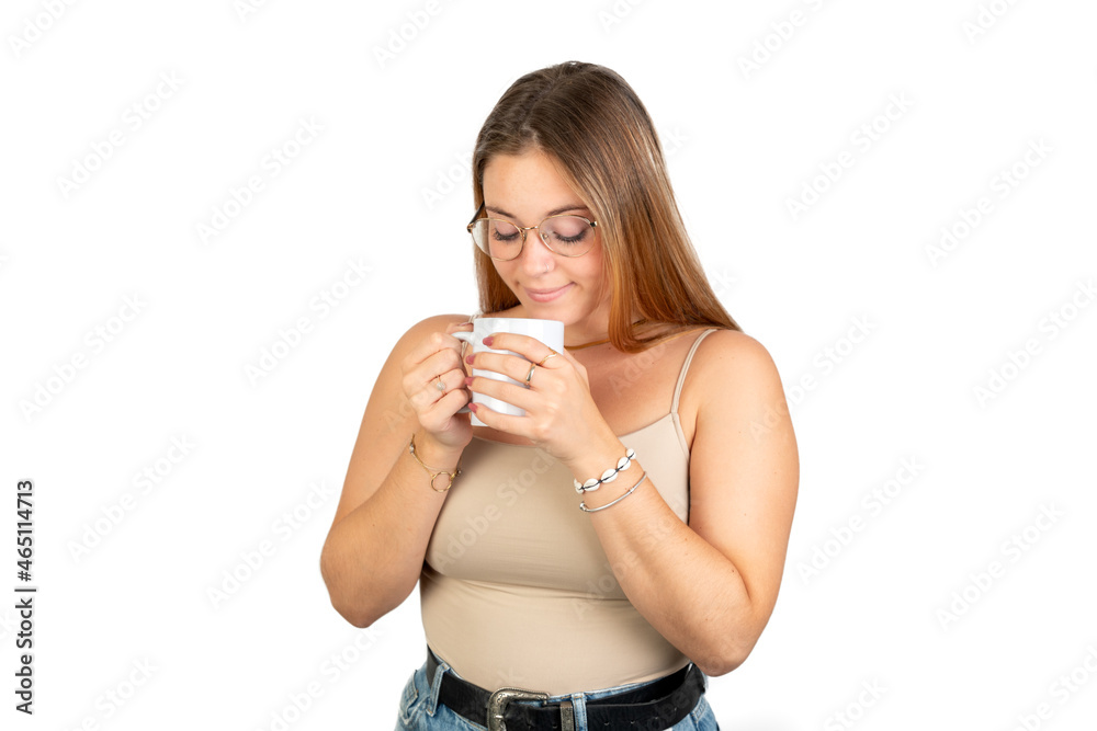 Young woman holding a hot cup and smelling it. 20-22 years old. Isolated on white background. White european woman. Hot Coffee-Tea concept. Young woman holding a hot cup and smelling it. 20-22 years old. Isolated on white background. White european woman. Hot Coffee-Tea concept.