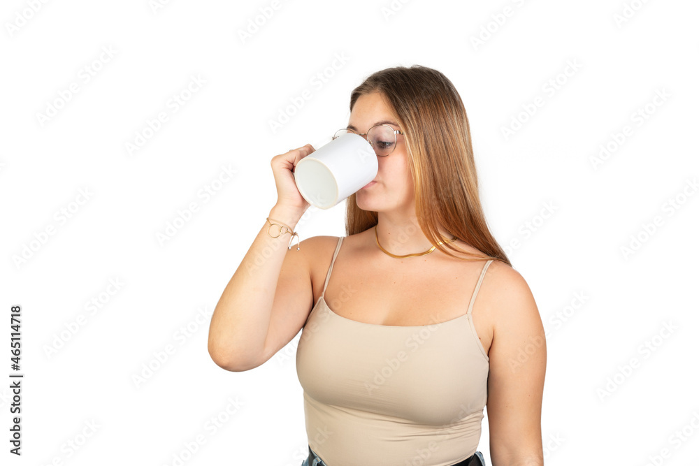 Young woman drinking from a cup. 20-22 years old. Isolated on white background. White european woman. Young woman drinking from a cup. 20-22 years old. Isolated on white background. White european woman.