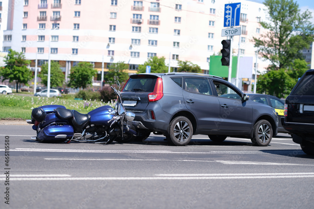 Motorcycle crashed into back of car on road closeup Motorcycle crashed into back of car on road closeup
