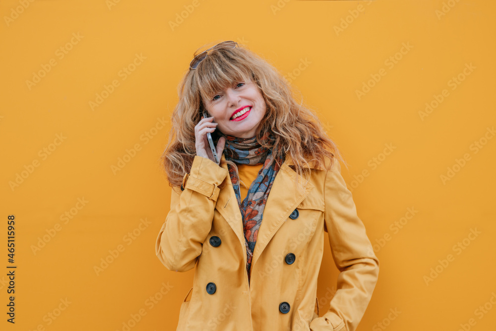 woman on the street with mobile phone and yellow wall woman on the street with mobile phone and yellow wall