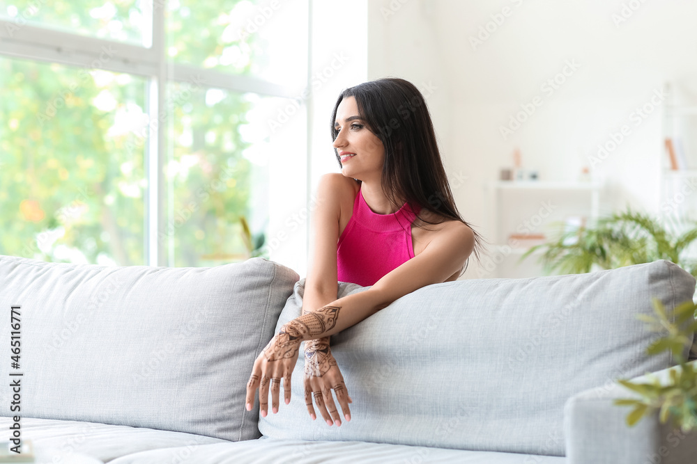 Beautiful Indian woman with henna tattoo at home