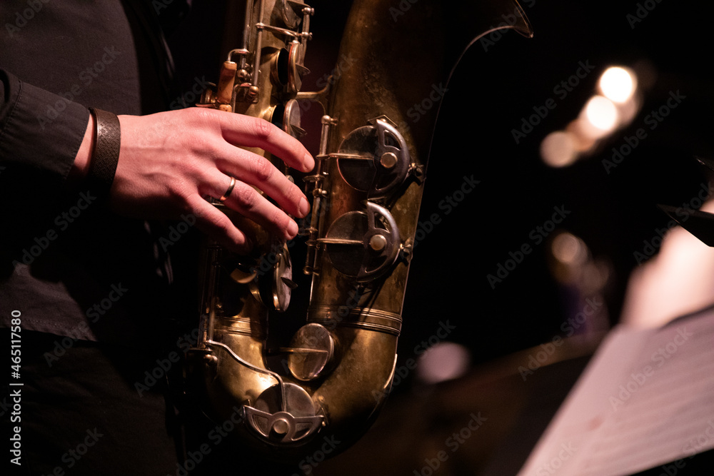 Obraz premium A tenor saxophone player playing a solo in front of a microphone during a live concert