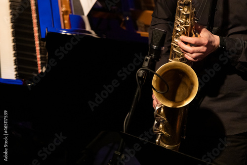 Фотография A tenor saxophone player dressed all in black from of a big band section playing
