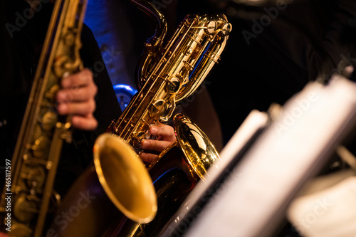 A baritone saxophone player getting his groove while playing in a sax section of a big band during a live concert performance photo