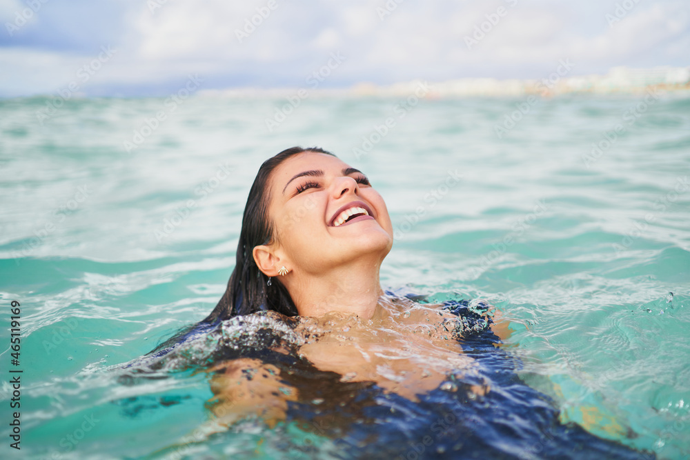 Cheerful woman swimming in clean water of sea