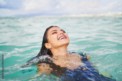 Cheerful woman swimming in clean water of sea