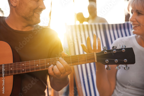 Mature man playing guitar a...