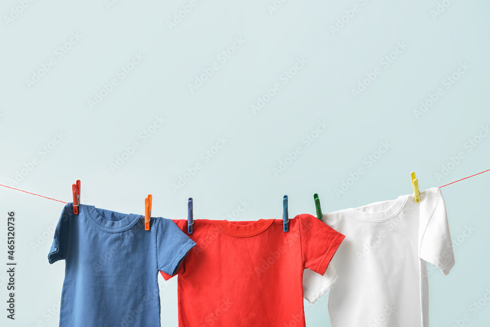 T-shirts hanging on rope against blue background
