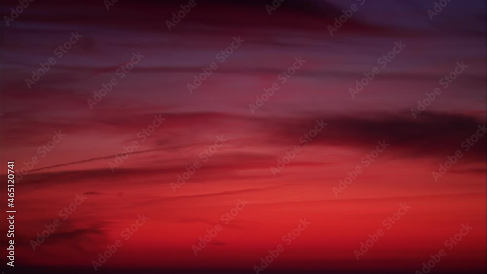 Skyscape. Red sky with clouds at sunset. Sky is getting dark. Evening nature landscape. Time lapse