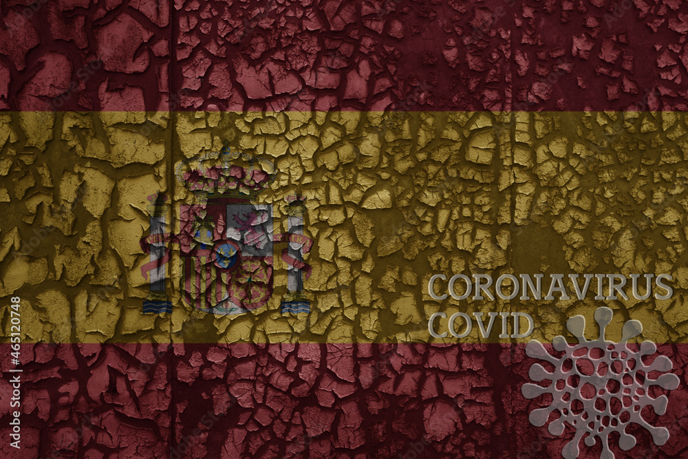 flag of spain on a old metal rusty cracked wall with text coronavirus, covid, and virus picture. flag of spain on a old metal rusty cracked wall with text coronavirus, covid, and virus picture.