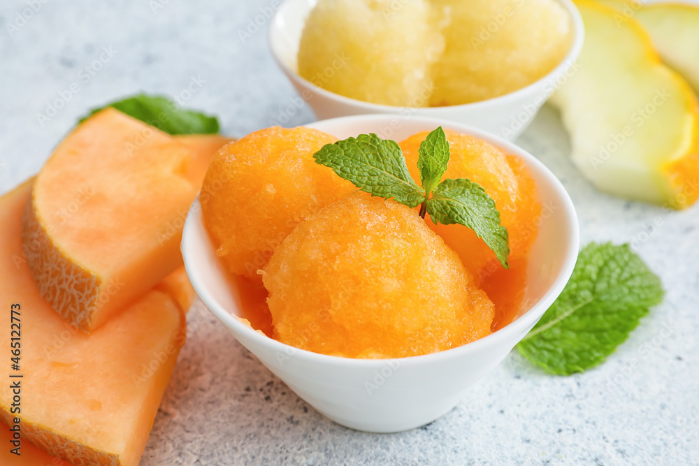 Bowls with tasty melon sorbet and mint on light background