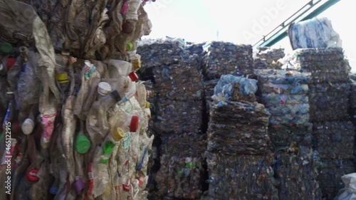 Bundle of pressed plastic bottles prepared for a garbage recycling on waste recycling plant. Camera moves to the side. Pollution problem. Stabilized video