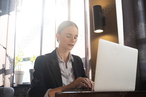 Girl freelancer working on a laptop in cafe. Work from home. Remote education