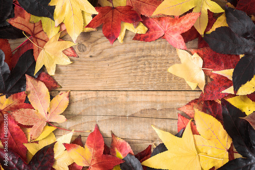Autumn background with colorful leaves on the rustic wooden top with copy-space